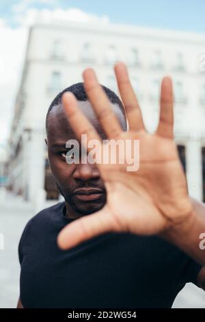 uomo che protesta ad un raduno per l'uguaglianza razziale che alza le braccia mostrando mano alla macchina fotografica. Le vite nere contano. Foto Stock