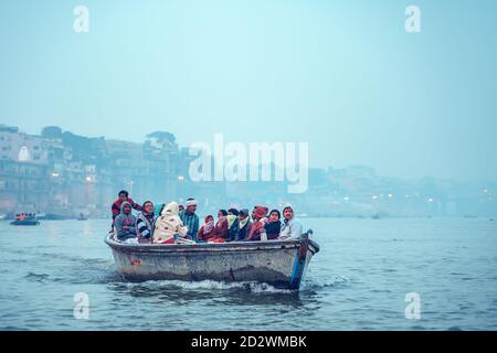 18.12.2019, Varanasi, India. Un gruppo di indiani sta navigando in barca nella mattina presto fredda. Spazio di copia. Foto Stock