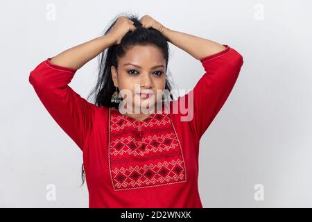 Ritratto di donna indiana con le dita nei suoi lunghi capelli e tirando contro di loro, adirata e frustrata signora. Foto Stock