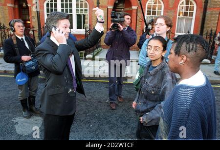 Alan Duncan (sinistra, telefono), assistente parlamentare al presidente del partito della Tory Brian Mahwhinney, chiede assistenza dopo aver perseguito tre giovani. I dimostranti precedenti hanno spruzzato il sig. Mahhinney con la vernice fuori della Camera dei Comuni. Foto Stock