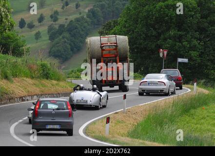 BOLOGNA, ITALIA - 12 MAGGIO 2008: Un tracotr-driver saluta i concorrenti di Mille miglia in una Jaguar XK 120 ITS, 1952 su una tortuosa strada nei pressi di Bologna durante il periodo di t Foto Stock