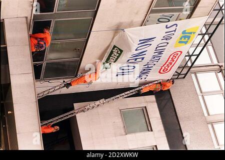 Gli attivisti di Greenpeace attaccano oggi una bandiera alle mura degli uffici di Conoco Oil nel centro di Londra (Weds) per protestare contro i loro piani di esplorazione petrolifera nella Atlantic Frontier sulla base del cambiamento climatico. Altri attivisti hanno formato una catena umana per bloccare l'ingresso al blocco degli uffici e altri tre stanno attualmente occupando l'ufficio del presidente, Roger Abel. I dimostranti rifiutano di lasciare l'edificio fino a quando Conoco, proprietario delle stazioni di rifornimento Jet, non darà loro la certezza che interromperanno i loro piani di esplorazione petrolifera in quella zona. Guarda la storia di PA. Foto di David Cheskin/ Foto Stock