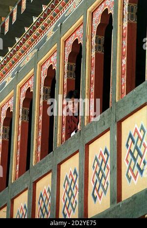 PA NEWS PHOTO 9/2/98 UN UOMO LOCALE SI TROVA FUORI DALLA FINESTRA AL PIANO SUPERIORE DI UNA CASA CHE MOSTRA L'ESTERNO DELLE TRADIZIONALI OPERE IN LEGNO DELL'AREA DELL'ANTICA CITTÀ DI PARO, BHUTAN, MENTRE IL PRINCIPE DI GALLES È IN VISITA LÌ Foto Stock