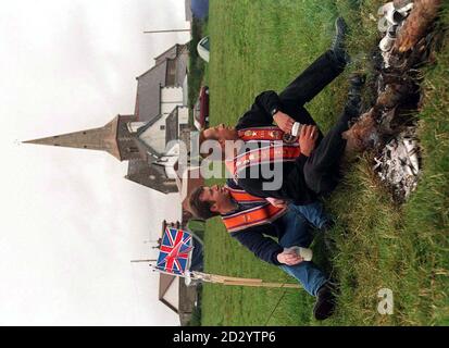 Orangemen sedersi intorno a un fuoco nel campo accanto alla chiesa Drumcree oggi (Lunedi). Foto di David Jones/PA Foto Stock