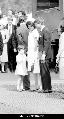 John finger il suo collare mentre parla con suo zio, il senatore Robert Kennedy, mentre attende con sua madre, Jacqueline Kennedy, e la sorella Caroline per incontrare la Regina al Kennedy Memorial sito, nei prati di Runnymede accanto al Tamigi. Foto Stock