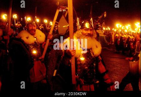 La 'squadra Jarl' di guizzatori - Shetlanders vestito in costume vichingo - forma una processione con la Galley, una longship di legno di 30 piedi, mentre canta la 'Casa del Norseman' a Lerwick, Isole Shetland, come parte di Up Helly AA in cui la barca è bruciata. * Up Helly AA ha avuto origine come festival pagano del Norse e poi è stato adottato dai cristiani per celebrare la fine del periodo santo cristiano con il digiuno e i falò. 25/5/02: La Scozia è oggi ufficialmente un paese pagano, secondo una ricerca pubblicata dal giornale della Chiesa d'Inghilterra. Il documento dice che 30 anni fa quasi tutti hanno rivendicato un Foto Stock