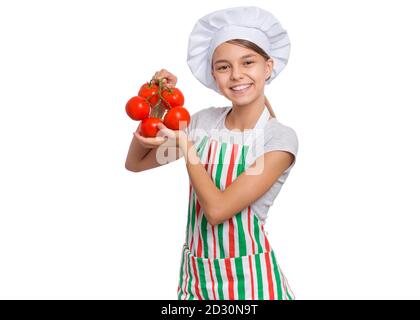 Ragazza che indossa un cappello da chef con emozioni che tengono in mano generi alimentari, isolato su sfondo bianco. Foto Stock