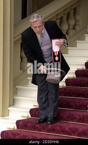 Il comico veterano Sir Norman Wisdom scherza in giro dopo aver ricevuto la sua Knighthood dalla Regina Elisabetta II della Gran Bretagna a Buckingham Palace a Londra. * Sir Norman, 85 anni, famoso per aver suonato il piccolo discendenti con una cuffia in tessuto e un vestito maledetto, è considerato uno dei preferiti della Regina e della Regina Madre, di 99 anni. Foto Stock