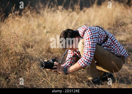 fotographer del giovane uomo che parla le immagini all'aperto sul tramonto Foto Stock