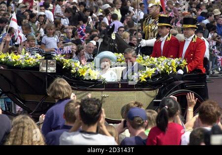 La Regina Madre con il Principe del Galles, in una carrozza trainata da cavalli, ondeggia verso le folle raccolte sul Mall, quando arriva a Buckingham Palace, Londra, per le sue celebrazioni del centesimo compleanno. Foto Stock