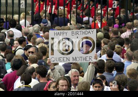 Le folle si radunano fuori Buckingham Palace a Londra, aspettando che la Regina Madre appaia sul balcone durante le celebrazioni del centesimo compleanno. Foto Stock