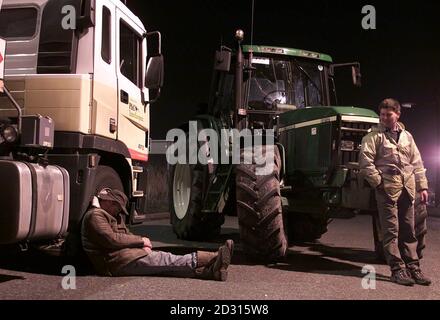 Un agricoltore gallese dorme contro la ruota di una petroliera Shell bloccata durante una protesta tutta la notte contro gli elevati prezzi del carburante, presso la raffineria petrolifera di Shell Stanlow a Cheshire. Gli agricoltori e i camionisti britannici si sono promessi di continuare la loro disgregazione in stile francese. * ...oltre i costi elevati del carburante dopo centinaia di anni si sono rivelati per bloccare una raffineria di petrolio a Stanlow, vicino a Ellesmere Port, Cheshire. Foto Stock