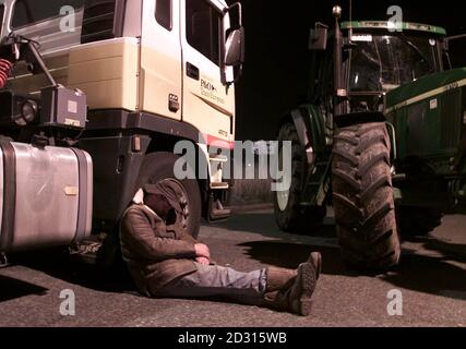 Un agricoltore gallese dorme contro la ruota di una petroliera Shell bloccata durante una protesta tutta la notte contro gli elevati prezzi del carburante, presso la raffineria petrolifera di Shell Stanlow a Cheshire. Gli agricoltori e i camionisti britannici si sono promessi di continuare la loro disgregazione in stile francese. * ...oltre i costi elevati del carburante dopo centinaia di anni si sono rivelati per bloccare una raffineria di petrolio a Stanlow, vicino a Ellesmere Port, Cheshire. Foto Stock