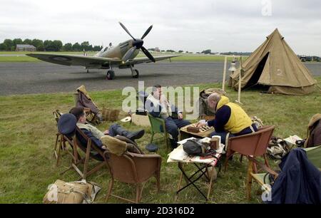 Gli attori in abito da combattimento in tempo di guerra si rilassano con un fuoco di sputa nel terreno di ritorno alla Battaglia di Gran Bretagna aperta giorno a Biggin Hill in Kent, che commemora il 60 ° anniversario della deafeat di Luftwaffe di Hitler nella seconda guerra mondiale. Foto Stock