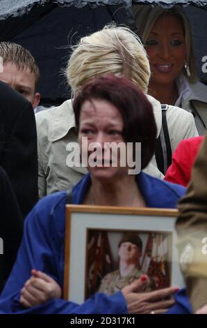 Lisa Billing porta dietro la sua bara una fotografia di suo figlio, il privato Daniel Wade, quando arriva per i suoi funerali alla chiesa di St Elphin, Warrington. Foto Stock