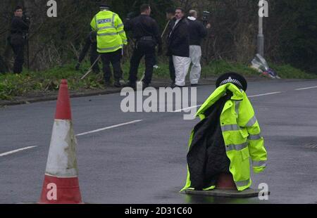 Gli ufficiali di polizia di Kent constabulary lavorano accanto ai fiori posati sul posto su Shottendane Road, Margate, Kent, dove PC Jon Odell è morto dopo una collisione con una macchina. Tre persone sono state arrestate in relazione all'incidente. Foto Stock