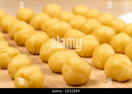 Piccole palle di pasta fresca fatta in casa biscotti su una tavola di legno, macro, sfondo Foto Stock