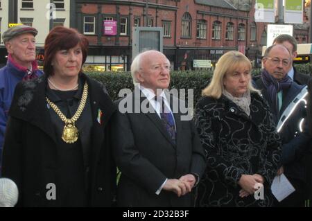 il presidente irlandese Michael D Higgins (al centro) si trova presso il sindaco di Liverpool Sharon Sullivan (a sinistra) e Wendy Simon, membro del governo per la cultura (a destra) al Great Hunger Memorial di Liverpool, in memoria di coloro che sono morti nella carestia irlandese, dove ha deposto una corona, Come parte di una visita di tre giorni a Liverpool e Manchester. Foto Stock