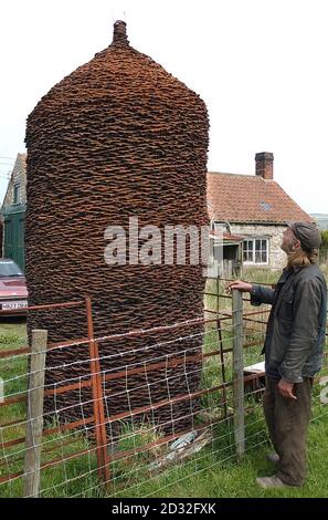 La scultura dei fabbri al di fuori del negozio Old Blacksmiths a North Grimston vicino a Malton dove i fabbri che lavorano nella zona aggiungono vecchie scarpe da cavallo alle colonne al di fuori della fucina quando sostituiscono vecchie scarpe sui loro clienti equini. * le colonne ora contengono oltre 25,000 scarpe e sono ancora in fase di aggiunta, come la zona di Malton è sede di una serie di scuderie da corsa. Foto Stock