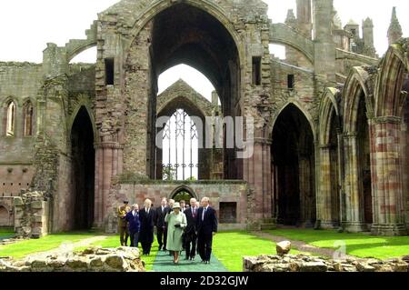 La Regina parla con Graham Munroe della Historic Scotland Society mentre visita l'abbazia di Melrose, nei confini scozzesi. La Regina visitò dove fu sepolto il cuore del re scozzese medievale Robert Bruce. Foto Stock