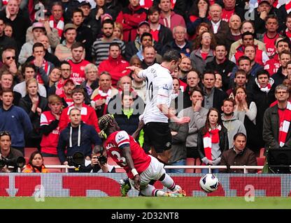 Il Bacary Sagna dell'Arsenal (a sinistra) fouls Robin van Persie del Manchester United per concedere una penalità Foto Stock