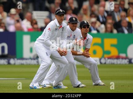 L'Inghilterra Joe Root (a sinistra), Graeme Swann (al centro) e Alastair Cook Field nel quarto giorno del secondo Investec Ashes Test al Lord's Cricket Ground, Londra. Foto Stock