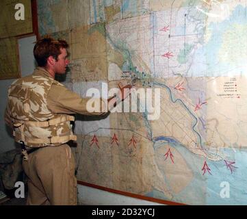 Il CAPT Ian Fake guarda le mappe lasciate nel quartier generale del partito Ba-ath a Basra mentre lo squadrone Cyclops del 2° Regiment reale dei carri armati prende la città nel sud dell'Iraq. Foto Stock