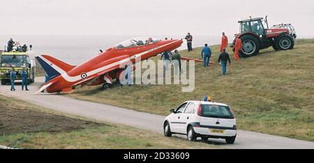La barra di traino si scollega quando i tecnici aerei utilizzano un trattore per recuperare un aereo RAF Red Arrows che ha superato l'estremità occidentale della pista all'aeroporto di Jersey. Nessuno dei due membri dell'equipaggio di Hawk, con base a RAF Scampton nel Lincolnshire, che stava arrivando a Jersey per intraprendere esposizioni nella zona più tardi questa settimana, è stato ferito. Foto Stock