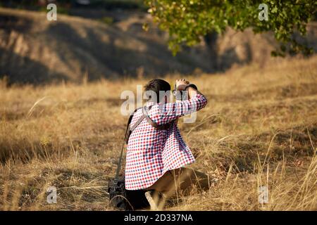 fotographer del giovane uomo che parla le immagini all'aperto sul tramonto Foto Stock