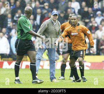 Un fan di Wolverhampton Wanderers (al centro) è tenuto lontano da Paul Ince dell'arbitro Uriah Rennie (a sinistra) dopo che Bolton Wanderers ha segnato il gol vincente, durante la partita della Barclaycard Premiership a Molineux, Wolverhampton. Bolton Wanderers ha vinto 2-1. QUESTA IMMAGINE PUÒ ESSERE UTILIZZATA SOLO NEL CONTESTO DI UNA FUNZIONE EDITORIALE. NESSUN UTILIZZO DI SITI WEB/INTERNET A MENO CHE IL SITO NON SIA REGISTRATO PRESSO LA FOOTBALL ASSOCIATION PREMIER LEAGUE. Foto Stock