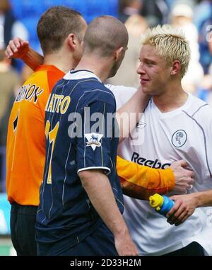 Alan Smith (a destra) di Leeds United abbraccia i suoi compagni di squadra Paul Robinson (a sinistra) e Dominic Matteo dopo la partita della Barclaycard Premiership contro Bolton Wanderers al Reebok Stadium di Bolton. Leeds United sono stati relegati dopo la loro sconfitta del 4-1. QUESTA IMMAGINE PUÒ ESSERE UTILIZZATA SOLO NEL CONTESTO DI UNA FUNZIONE EDITORIALE. NESSUN UTILIZZO DI SITI WEB/INTERNET A MENO CHE IL SITO NON SIA REGISTRATO PRESSO LA FOOTBALL ASSOCIATION PREMIER LEAGUE. Foto Stock