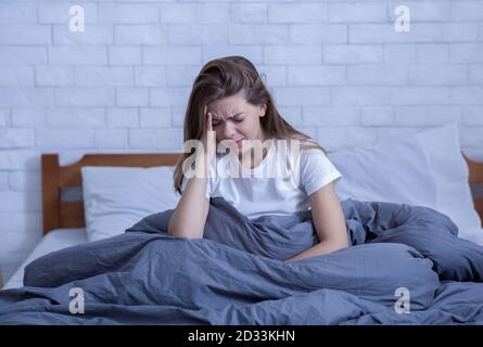 Donna solitaria stressata con disturbi mentali, affetta da depressione o emicrania, priva di sonno a causa di PTSD Foto Stock