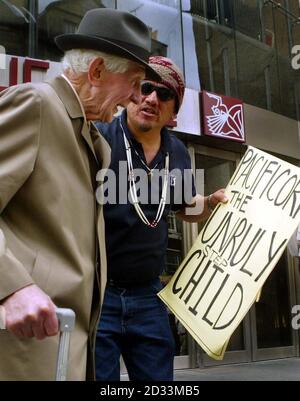 Un membro della tribù Yurok - che sono indiani nativi del Nord America - parla con l'azionista al di fuori dell'assemblea generale annuale di ScottishPower al Festival Theatre di Edimburgo. La controllata di ScottishPower negli Stati Uniti possiede e gestisce un complesso di dighe sul fiume Klamath, che secondo gli indiani americani ha degradato la qualità dell'acqua sul fiume e ha contribuito a un grande calo del numero di salmoni in quello che un tempo era il terzo più grande fiume di salmoni d'America. Foto Stock