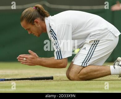 SOLO PER USO EDITORIALE: NESSUN USO COMMERCIALE. Xavier Malisse dal Belgio si mette in ginocchio dopo aver sconfitto Richard Krajicek dall'Olanda nella partita finale del quarto Mens sulla Corte uno a Wimbledon. Malisse combatté Krajicek con cinque set vincendo 6:1/4:6/6:2/3:6/9:7. Foto Stock