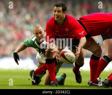 Wales mischia Half Gareth Cooper (centro) ottiene il suo passaggio via malgrado una sfida dal Peter Stringer irlandese (a sinistra) durante la partita RBS 6 Nations al Millennium Stadium di Cardiff. Foto Stock