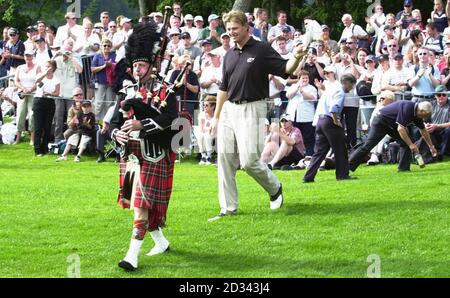 Il sudafricano Ernie Els segue il giocatore di cornamusa sulla strada per ricevere il trofeo dopo aver vinto il Barclays Scottish Open, al Loch Lomond Golf Club vicino a Balloch, Scozia. Foto Stock