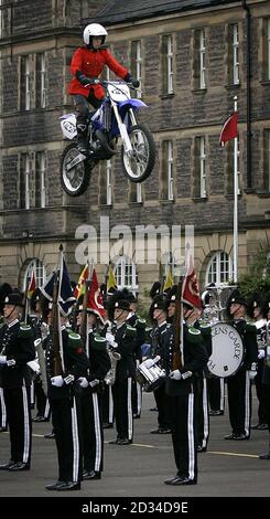 Un membro del team di visualizzazione della moto Imps salta sulla Guardia di sua Maestà il Re di Norvegia Band e Drill team. Foto Stock