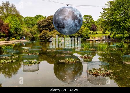 Un modello gigante della Luna (Museo della Luna di Luke Jerram) sorge sopra il Queen’s Park Pond durante il Brighton Festival, Brighton, Sussex, Regno Unito Foto Stock