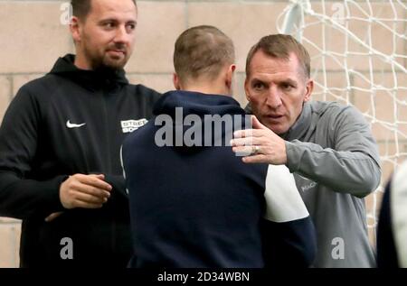 Il Leigh Griffiths di Celtic (al centro) è abbracciato dal manager Brendan Rodgers (a destra) accanto al fondatore e CEO di Street Soccer David Duke (a sinistra) mentre le squadre di Street Soccer di uomini e donne prendono parte a una sessione di allenamento speciale a Lennoxtown, Glasgow. Foto Stock