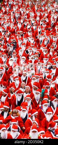 Centinaia di persone indossano abiti Santa per partecipare alla Great Scottish Santa Run, nei Princes Street Gardens di Edimburgo. Foto Stock
