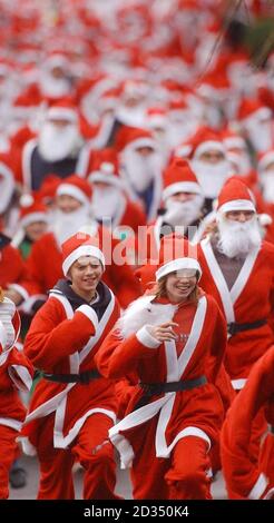 Centinaia di persone indossano abiti Santa per partecipare alla Great Scottish Santa Run, nei Princes Street Gardens di Edimburgo. Foto Stock