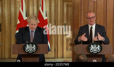 Una proiezione ripresa dal PA Video del primo Ministro Boris Johnson (da sinistra a destra) e del Capo consigliere scientifico Sir Patrick Vallance durante una conferenza stampa sul piano d'azione del governo per il coronavirus, al 10 Downing Street, Londra. Foto Stock