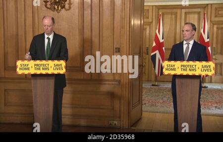 Schermata del Chief Medical Officer Chris Whitty (a sinistra) e del Segretario degli Esteri Dominic Raab durante un briefing sui media a Downing Street, Londra, sul coronavirus (COVID-19). Foto Stock