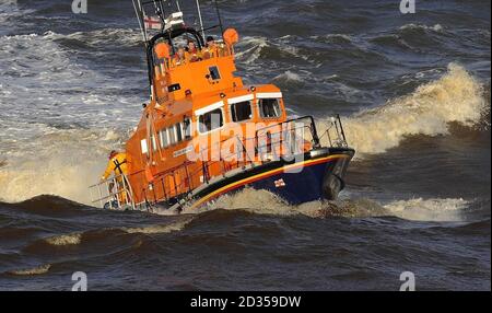 L'equipaggio della Whitby Life Boat torna dopo che una piccola barca è affondata In acque irregolari fuori dal porto di Whitby Foto Stock