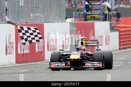 Sebastian Vettel, della Red Bull, in Germania, celebra la sua vittoria mentre supera la bandiera a scacchi durante il Gran Premio di Silverstone, nel Northamptonshire. Foto Stock