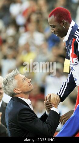 La Grande Britannia Phillips Idowu viene presentata con la sua medaglia d'oro di Jonathan Edwards dopo la sua vittoria nelle finali del triplice salto degli uomini durante i Campionati del mondo IAAF all'Olympiastadion, Berlino. Foto Stock