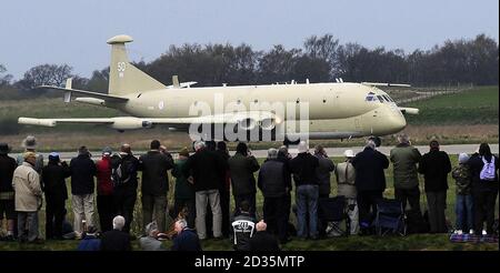 La gente guarda un aereo da ricognizione militare MR2 Nimrod mentre atterra al Museo dell'aria dello Yorkshire vicino a Elvington, York. Il Nimrod ha fatto il suo volo da RAF Kinloss per diventare la mostra del premio al museo ed è l'unico esempio dal vivo in esposizione in qualsiasi museo del mondo. Foto Stock