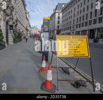 Westminster, Londra, Regno Unito. 7 ottobre 2020. I cartelli di avvertimento in anticipo sul lato ovest per l'installazione delle luci di Natale. A metà distanza un pilota su uno scooter elettrico guida lungo il marciapiede ad alta velocità dando a tutti coloro che lamentano il dito e maledicono. Credit: Malcolm Park/Alamy Live News. Foto Stock