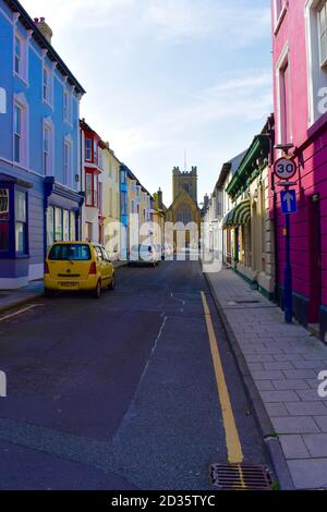 La vista lungo New Street nel centro della città di Aberystwyth.Pretty case color pastello e Chiesa di St Michaels in lontananza. Foto Stock