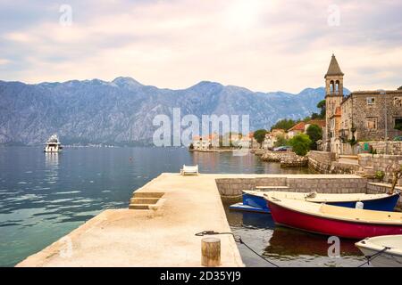 Pittoresco villaggio mediterraneo con case in pietra contro le montagne grigie, Montenegro, Baia di Cattaro (mare Adriatico), Stoliv villaggio. Concetto di viaggio, Foto Stock